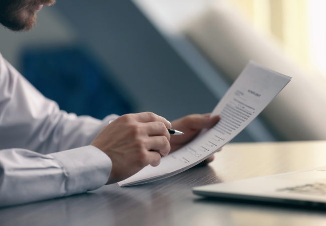 a person holding a paper reviewing and reading